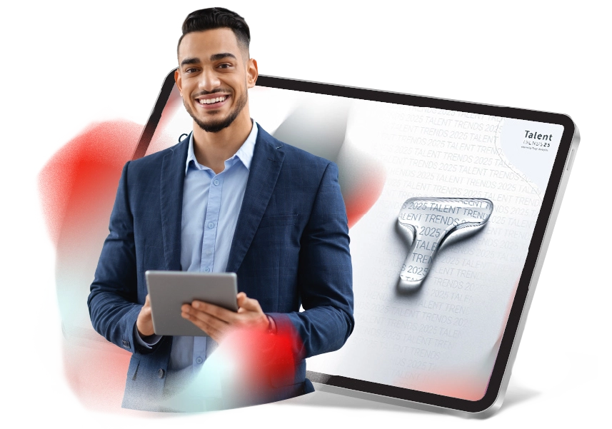 Un homme souriant avec une tablette entre les mains se tient debout devant l'image d'une tablette où apparaît la première page de Talent Trends.