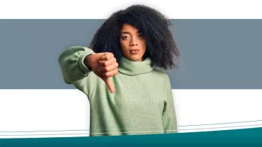 Person in green sweater giving thumbs down gesture