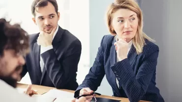 Mensen in een vergaderruimte, in gedachten verzonken.