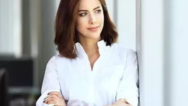 Personne en chemise blanche regardant par la fenêtre.