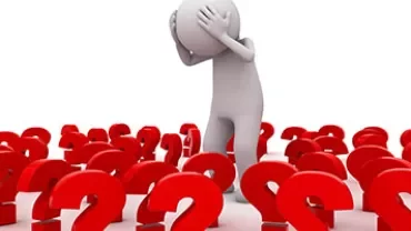Figure surrounded by many large red question marks.