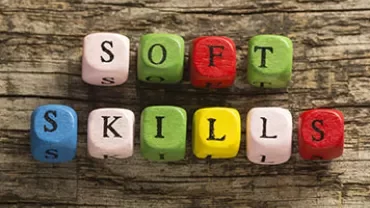 Colorful wooden blocks spell out 'soft skills' on a rustic surface.
