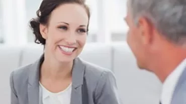 Two people having a conversation while smiling.