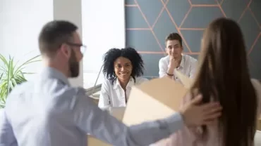 Groupe de personnes en réunion dans un bureau moderne.