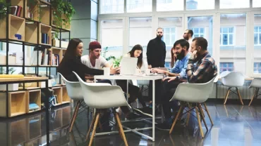 Équipe collaborant autour d'une table dans un bureau moderne.