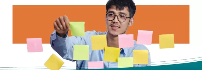 Persoon organiseert kleurrijke plakbriefjes op een glazen bord.