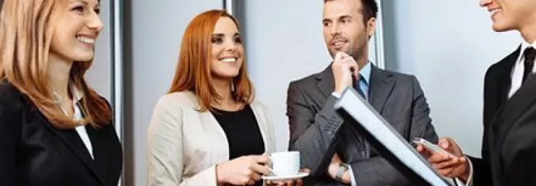 Groupe de personnes en tenue professionnelle discutant amicalement.