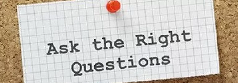 Note épinglée sur un tableau avec le texte: 'Posez les bonnes questions'.