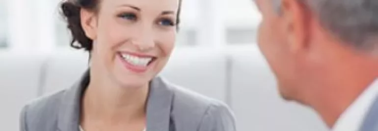 Two people having a conversation while smiling.