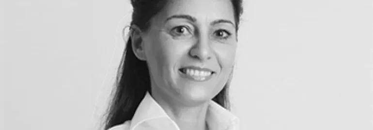 Smiling person in a white shirt, black and white photo.