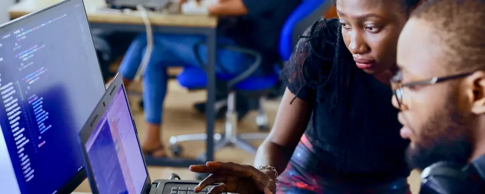 Twee mensen werken samen aan een computer op kantoor.